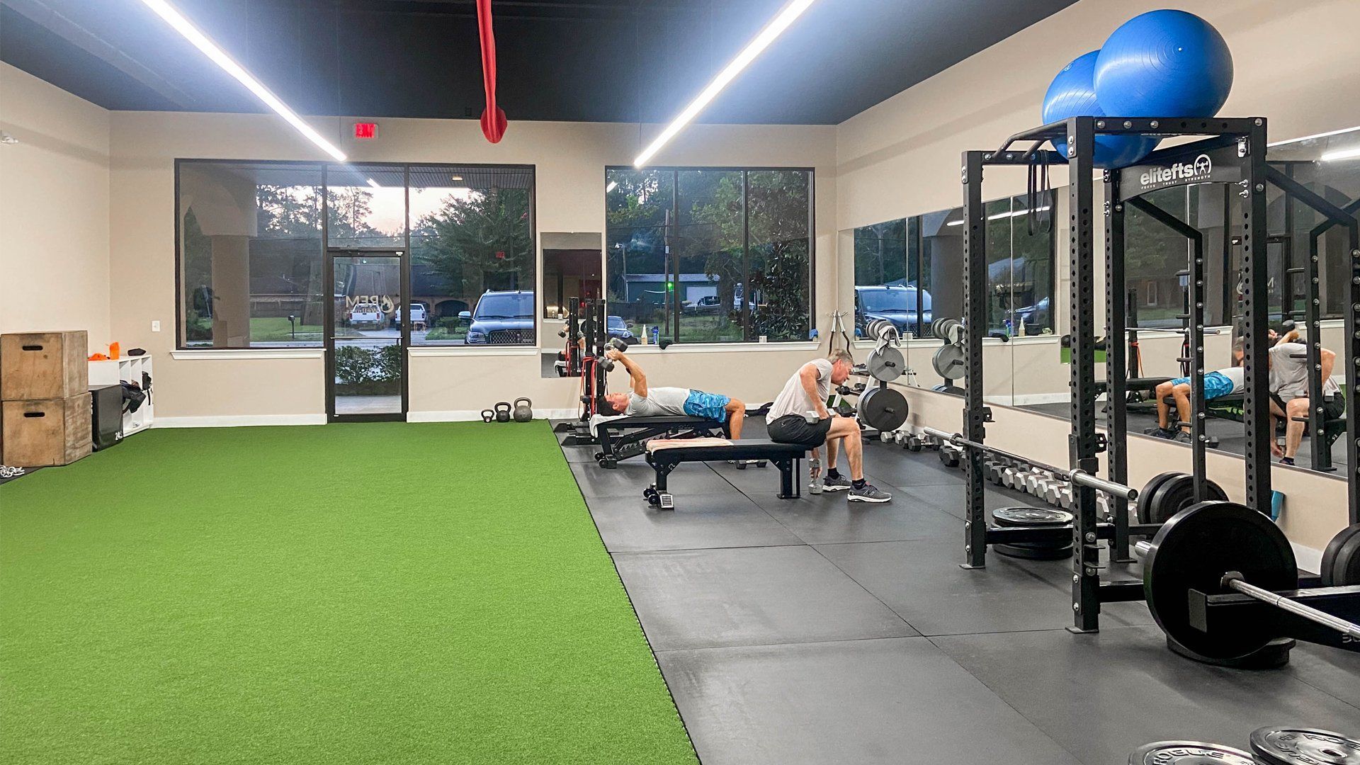 A group of people are sitting on benches in a gym.