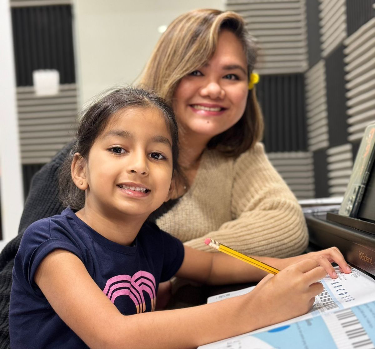 A woman and a little girl are sitting at a desk