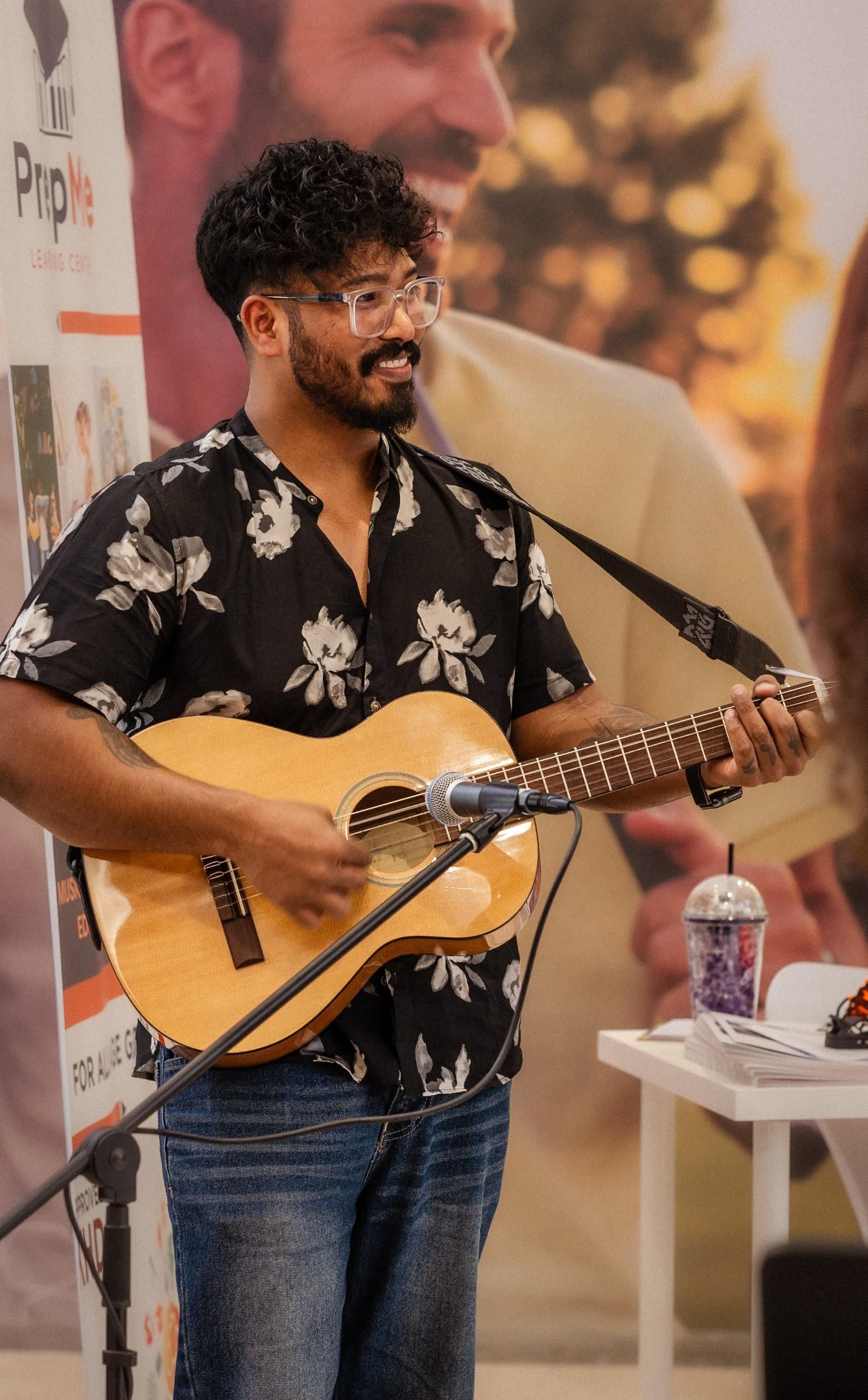 A man is playing a guitar in front of a microphone.