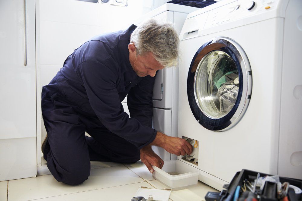 Man Fixing Broken Washing Machine — Elite Appliance Services in Boat Harbour, NSW