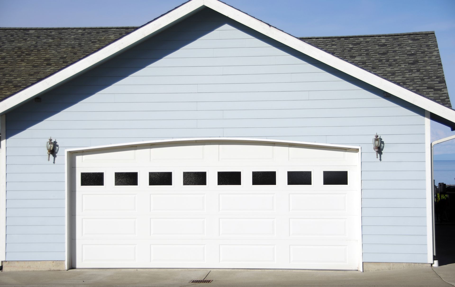 Arched garage door opening on a new home, showcasing the work of a local garage door contractor.