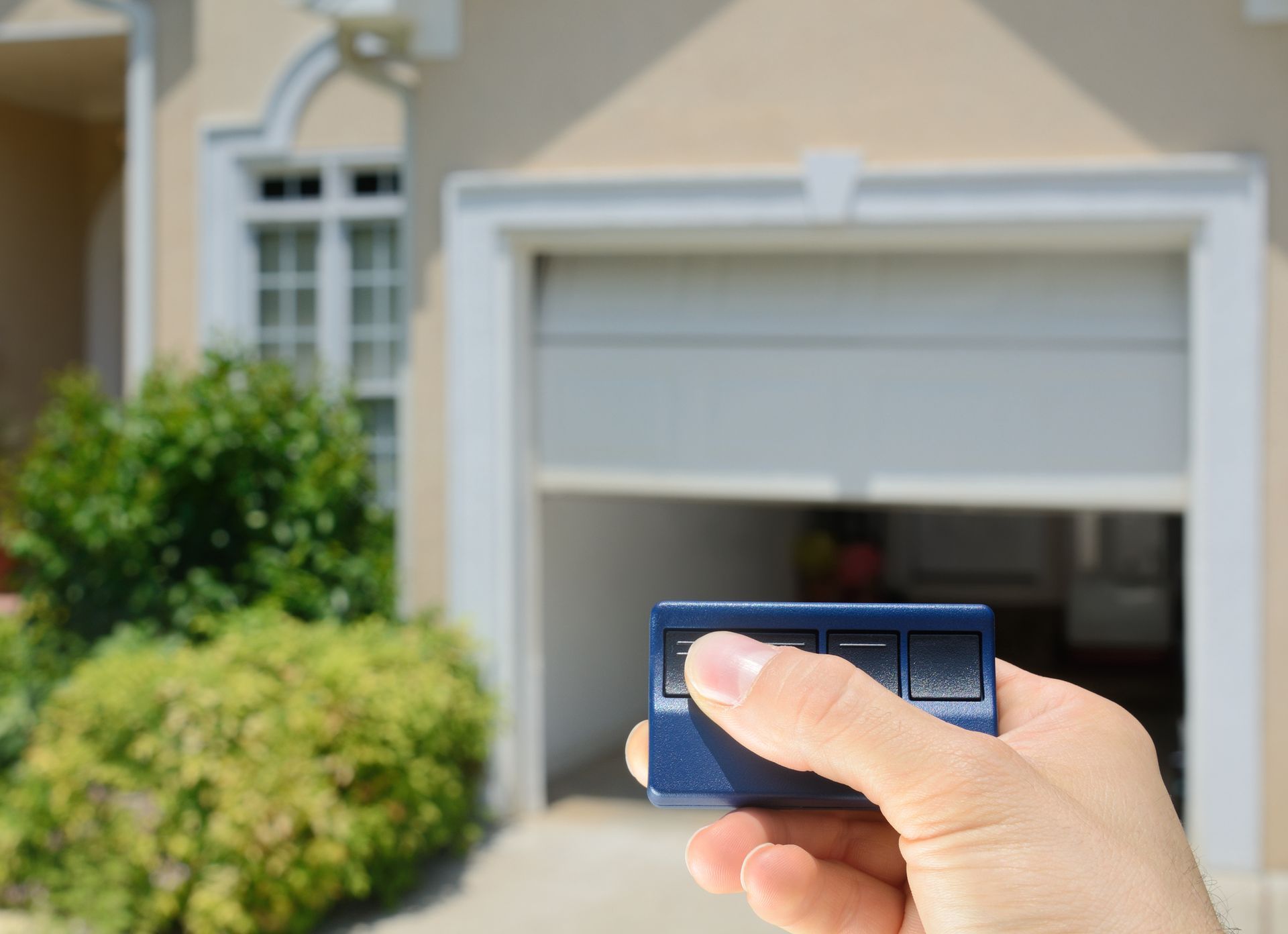 Technician working on a white garage door opener repair in a residential.