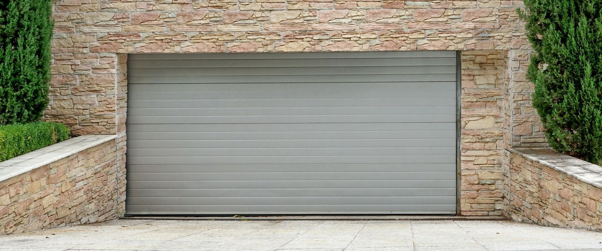 Roll-up garage door closed, on a building’s brick wall, representing garage door repair.