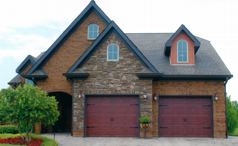 A large brick house with two red garage doors