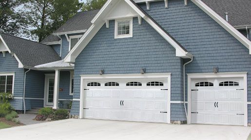 A blue house with two white garage doors