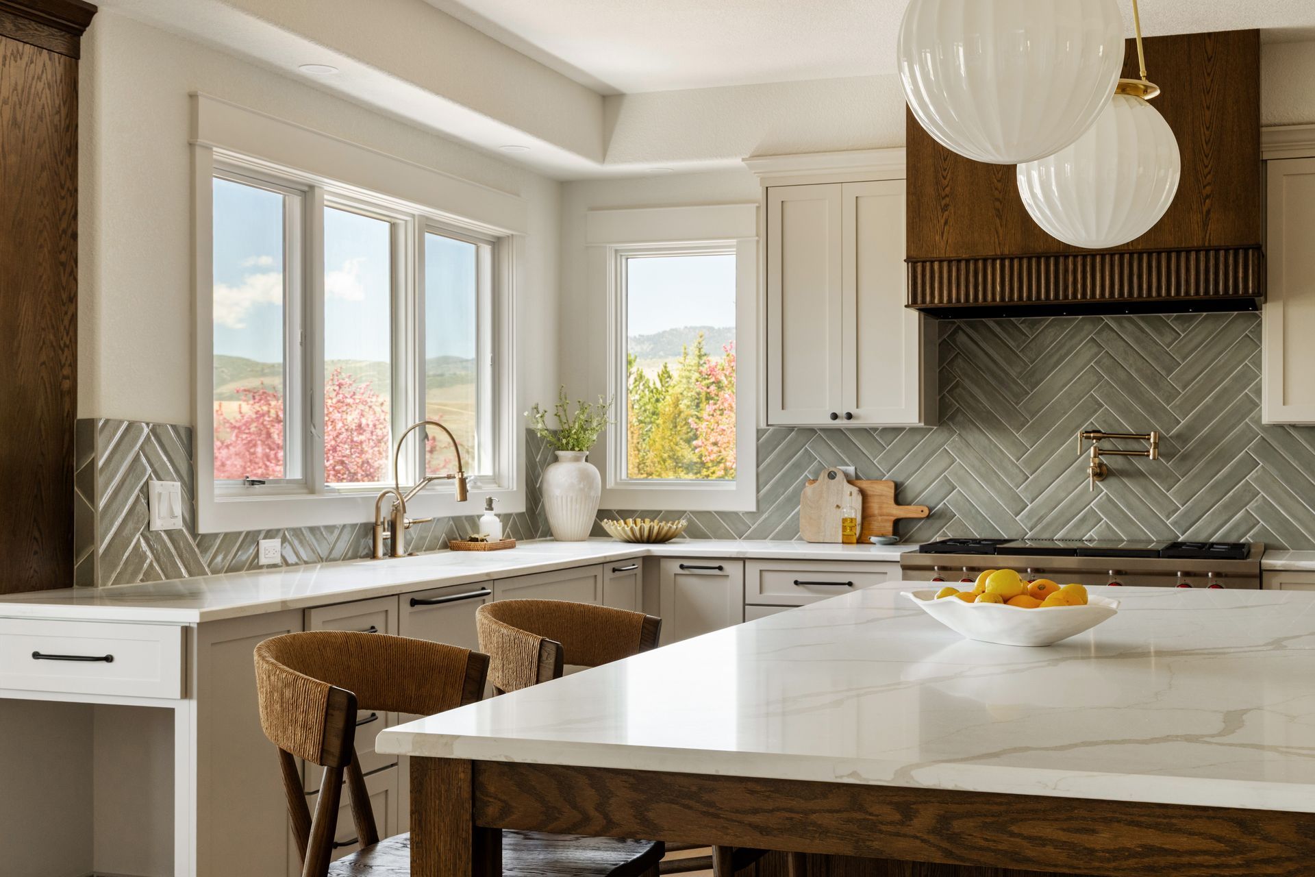 Bright, modern kitchen with white cabinets, marble countertops, and a central island.