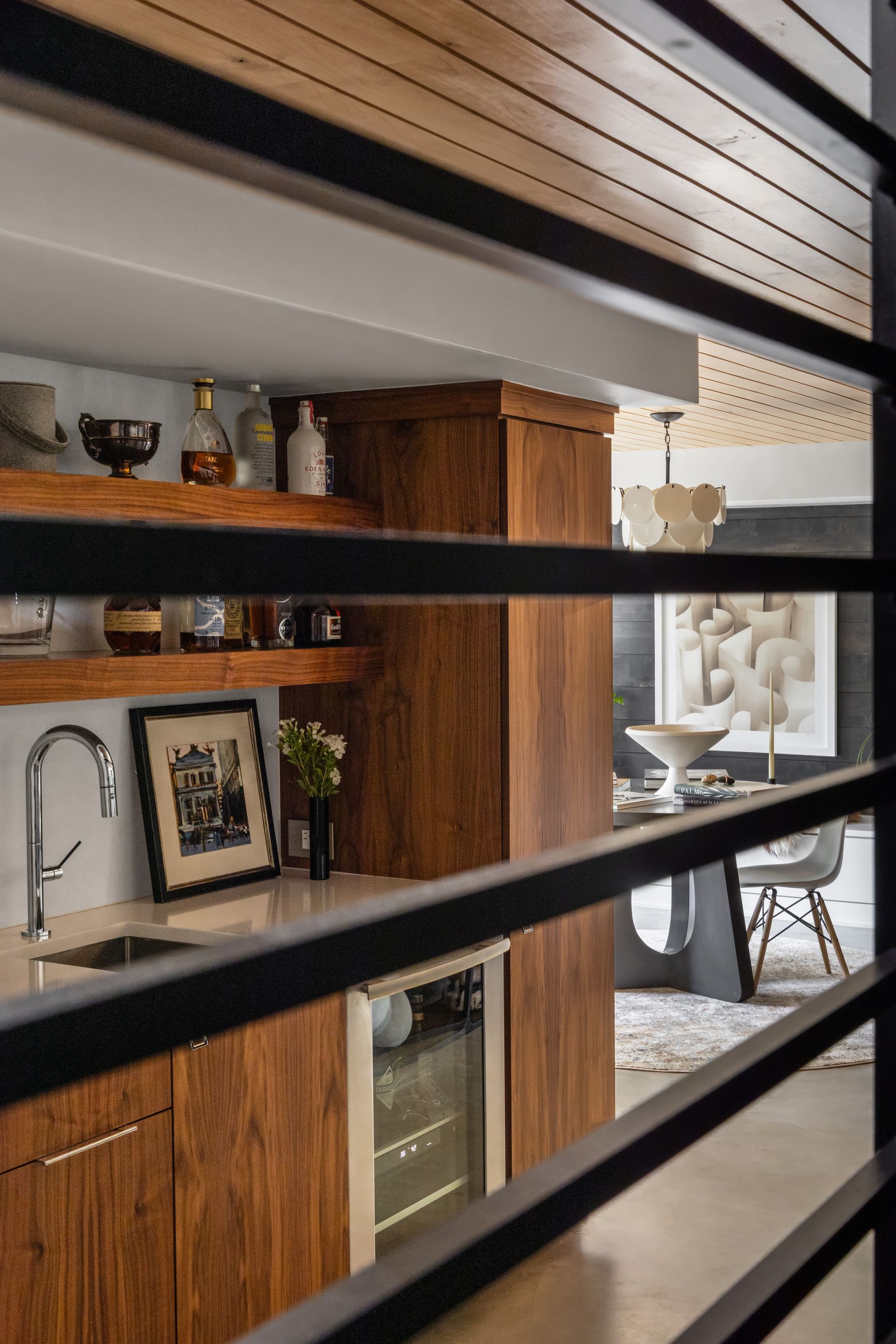 Wooden bar with liquor, sink, wine fridge, photo, and decorative ceiling.