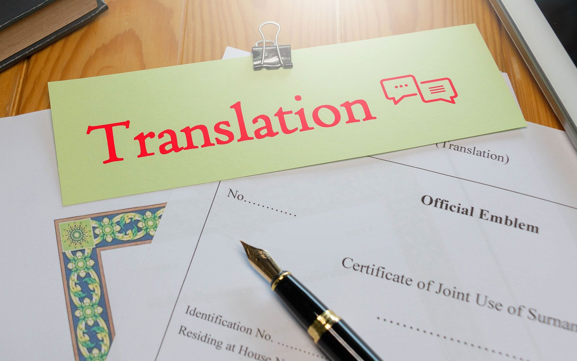 Desk with translation documents, fountain pen, and a sign that says