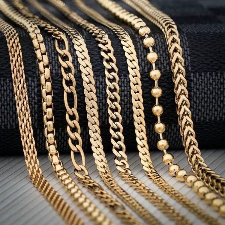 Assorted gold chains including Cuban links and beaded styles on black background.