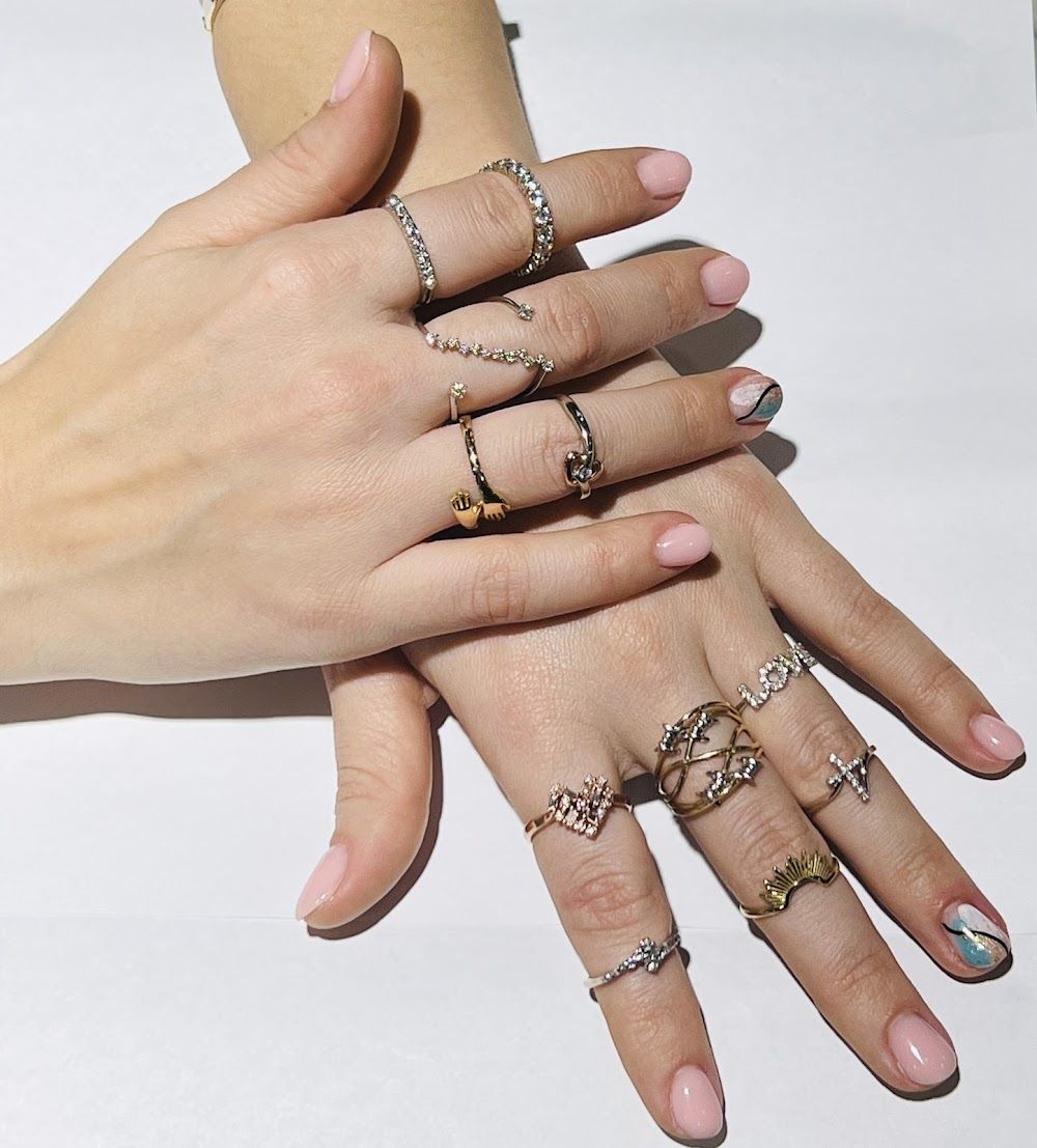 Woman’s hand adorned with custom gold rings from Marcelo’s Jewelry.