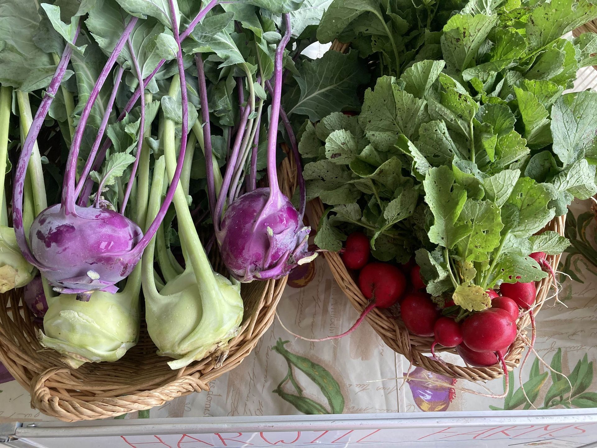 Three baskets filled with different types of vegetables are sitting on a table.