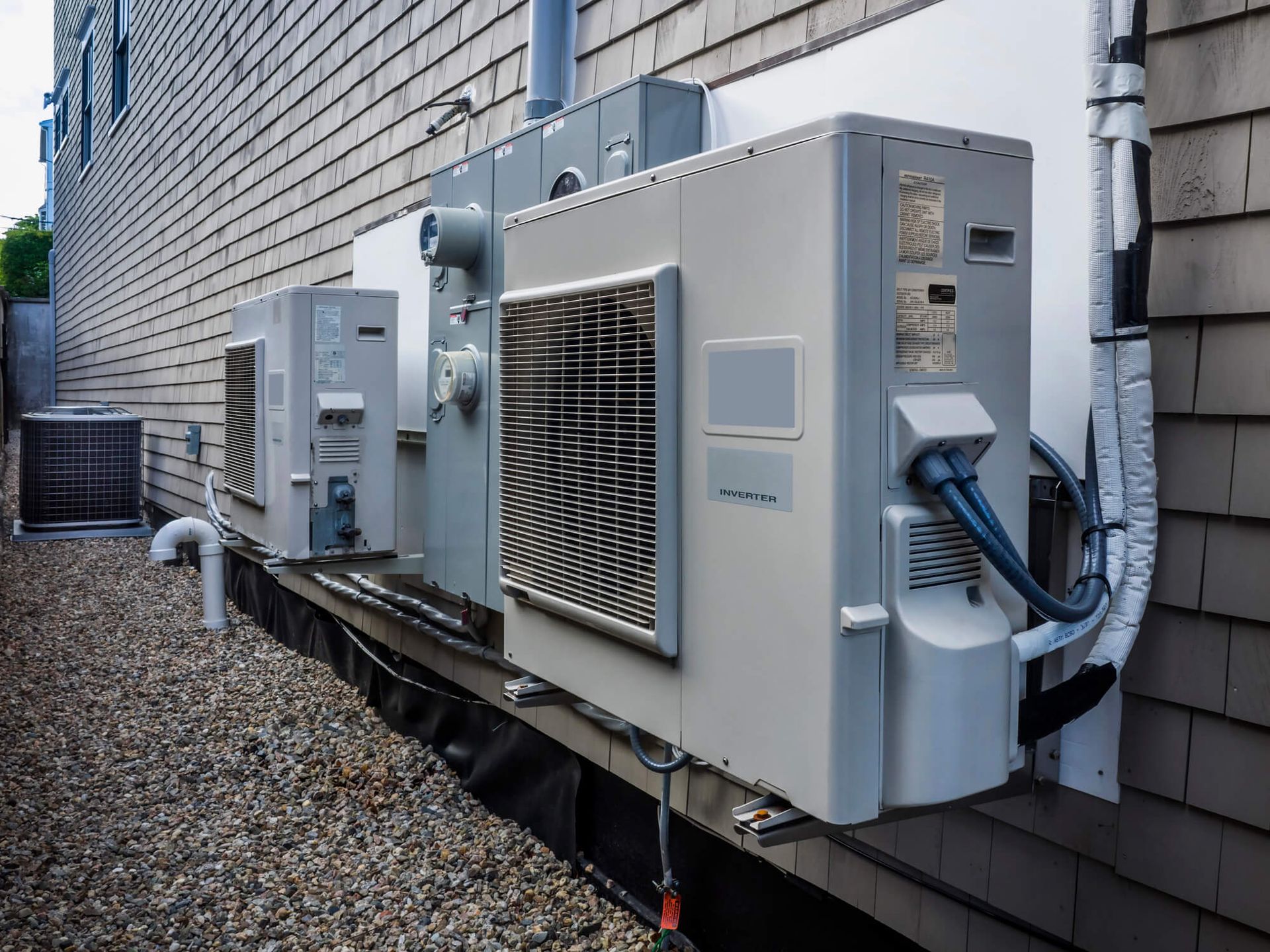 A row of air conditioners on the side of a building.