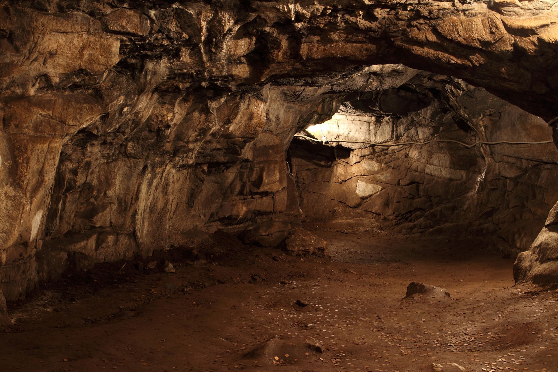 A cave with a lot of rocks and a light coming out of it.