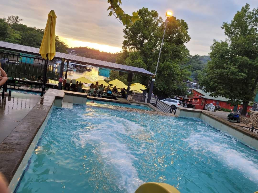 A large swimming pool with a yellow umbrella in the background.