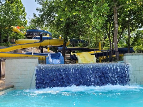 A water park with a waterfall and a slide