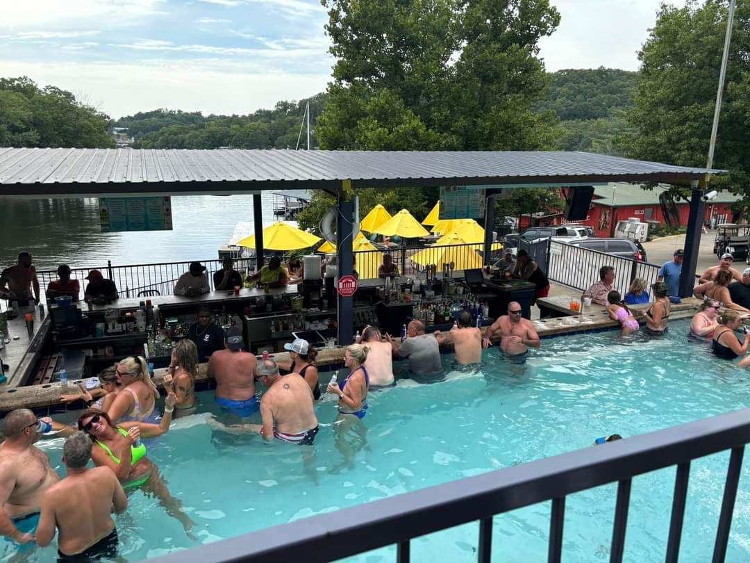 A group of people are sitting in a large swimming pool.