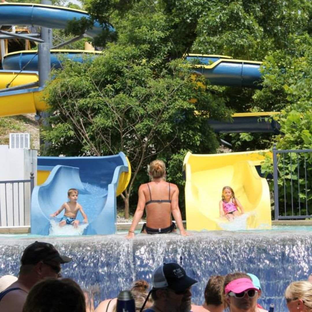 A group of people are playing on water slides at a water park