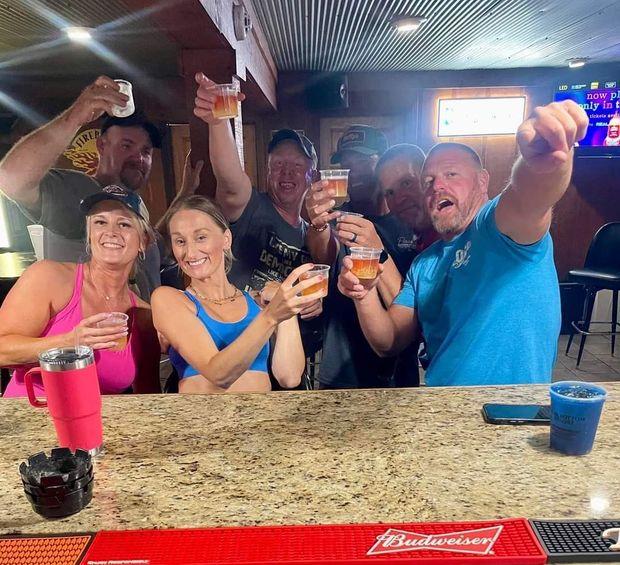 A group of people toasting with budweiser beer