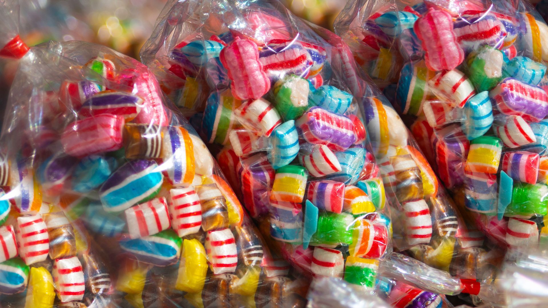 Bags of colorful, wrapped hard candies, including red, white, blue, and yellow stripes.
