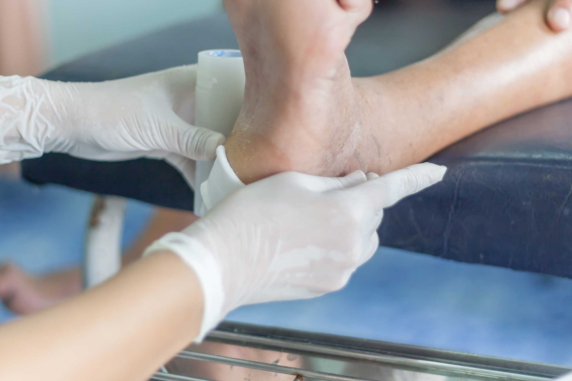 Close view of hands with gloves curing the foot of a diabetic patient. Close view of hands with gloves curing the foot of a diabetic patient.