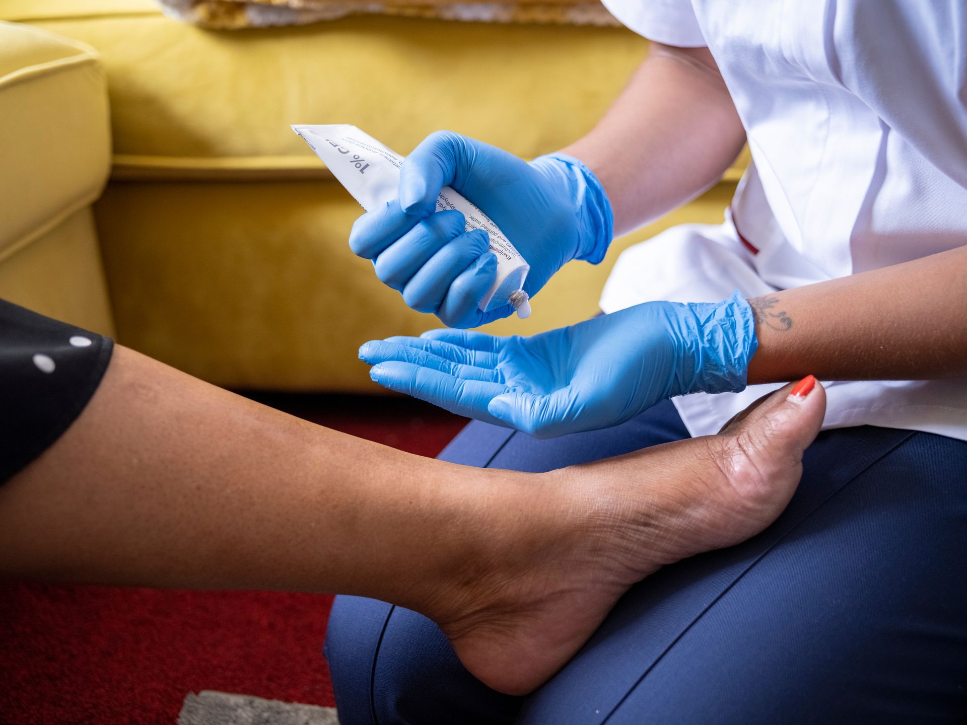 A close-up of a nurse taking care of a woman's foot.