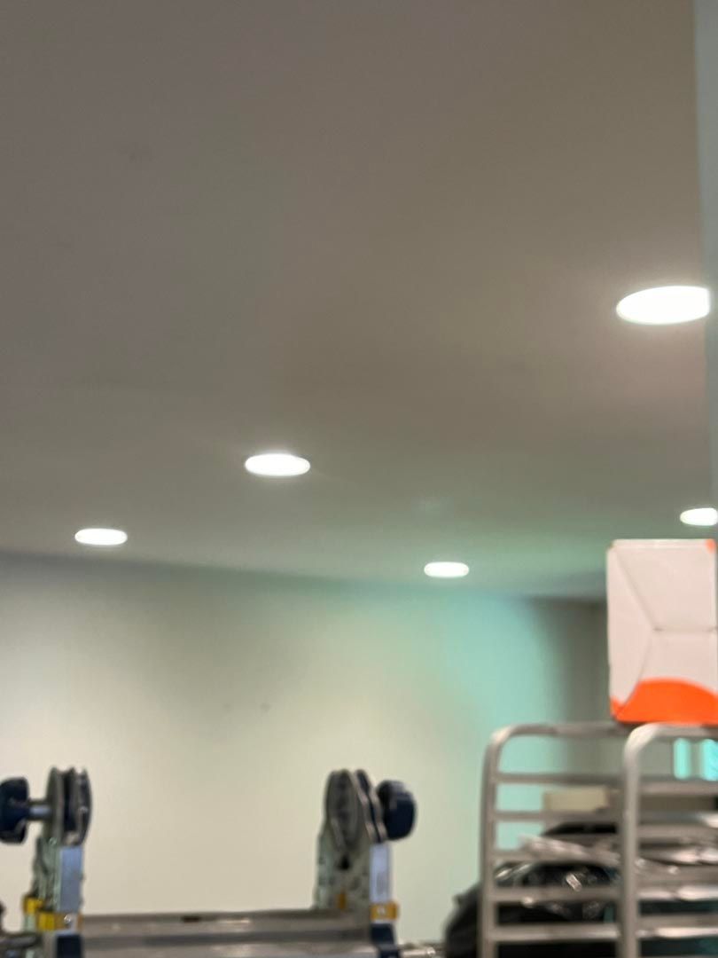 A ladder is sitting under a ceiling in a room.