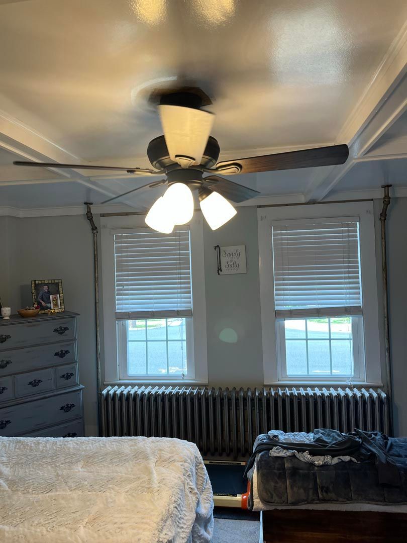 There is a ceiling fan in the corner of the room.