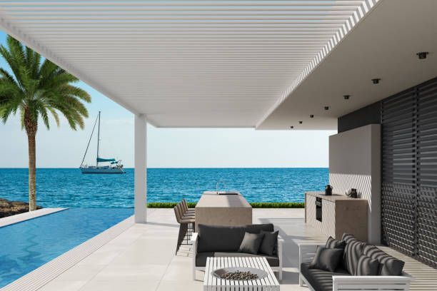 Luxury seaside patio with pool, palm tree, and ocean view through open terrace.