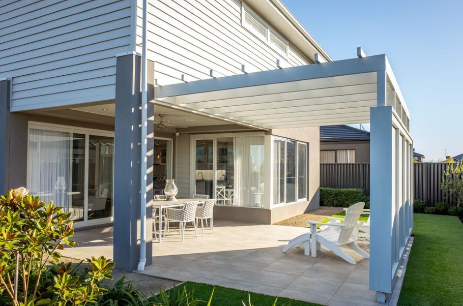 Modern house patio with white outdoor chairs and sliding glass doors
