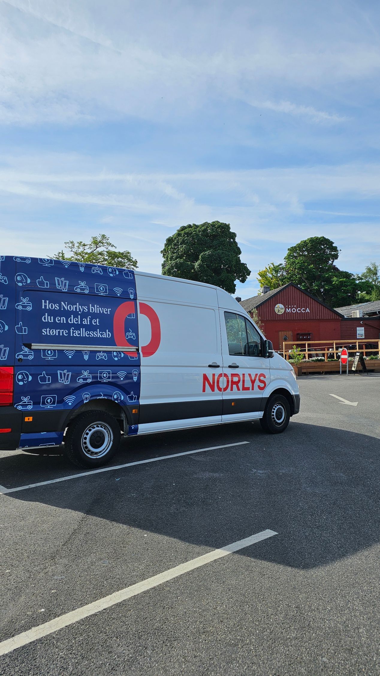 En hvis og blå varevogn parkeret på havnen
