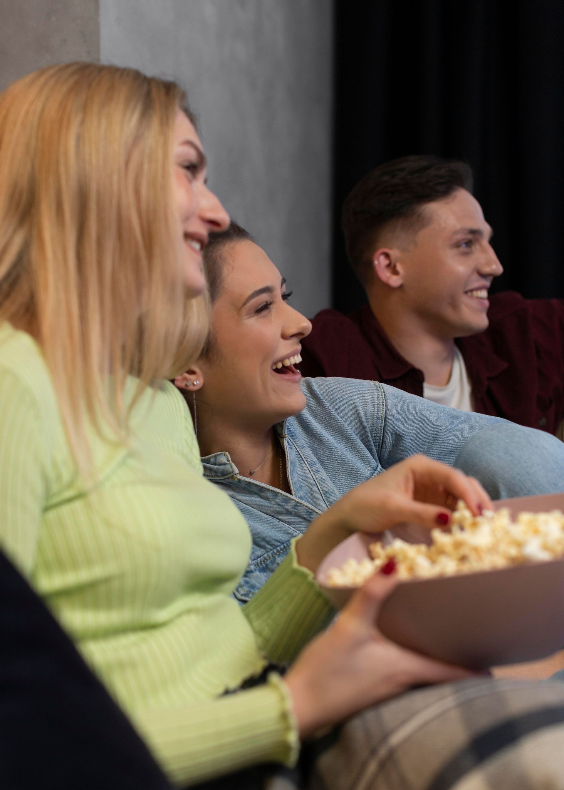 En gruppe mennesker sidder i sofaen og popcorn
