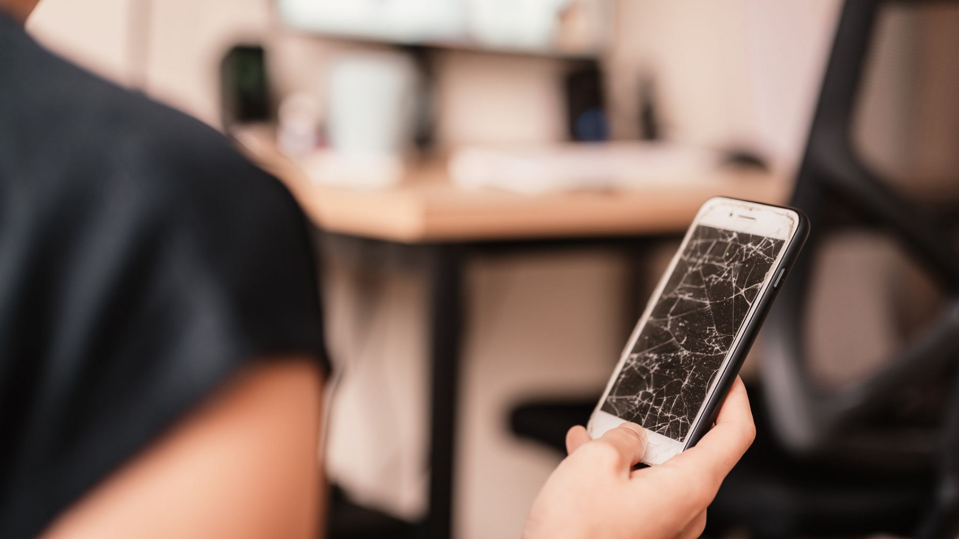 Kvinde ligger på en sofa og kigger på sin telefon imens hun smiler