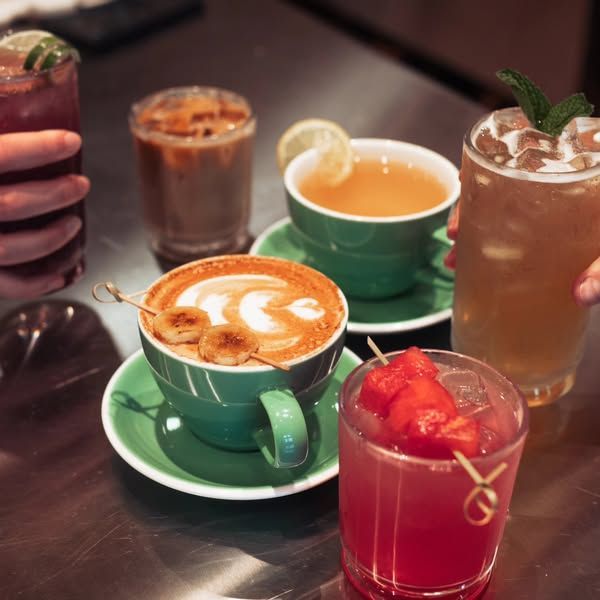 A table full of drinks including a cup of cappuccino