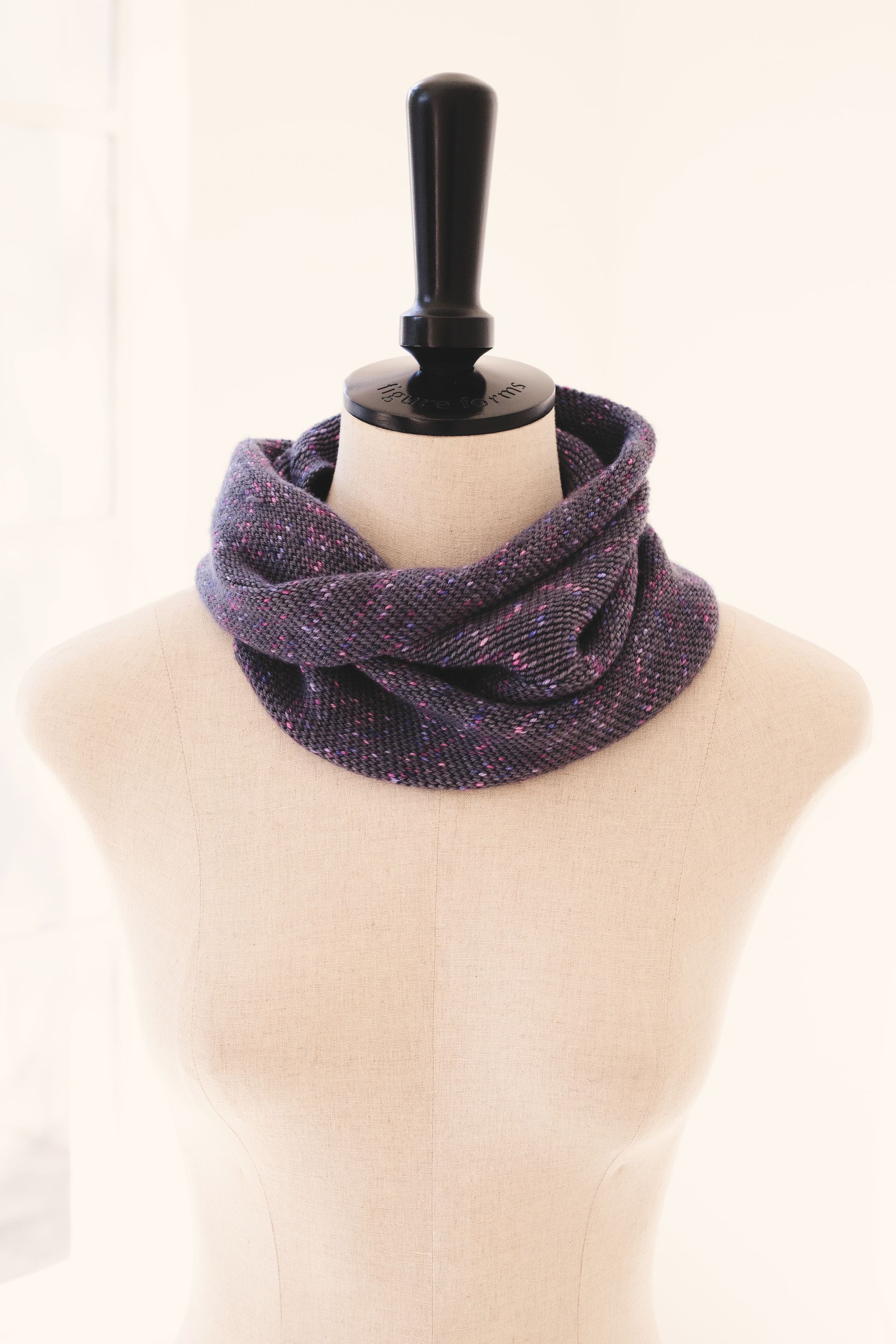 Purple knit cowl scarf on a mannequin.