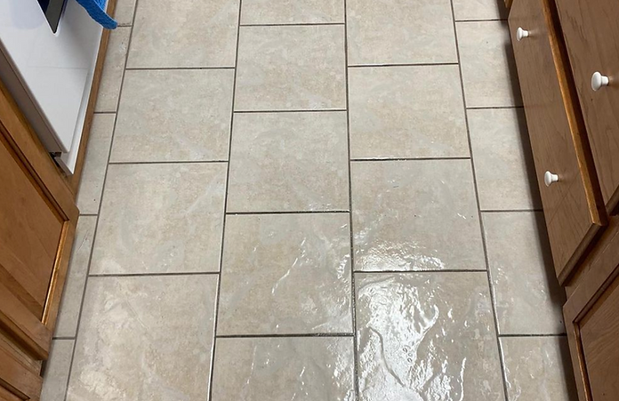 A kitchen floor with tiles and wooden cabinets