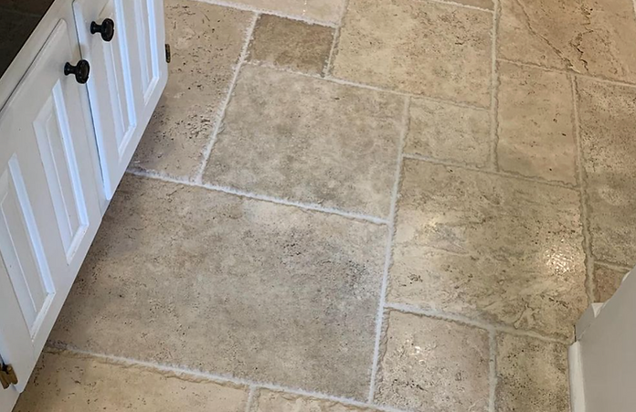 A kitchen with a tile floor and white cabinets.