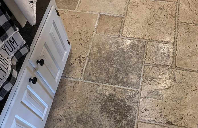 A kitchen with a tile floor and white cabinets.