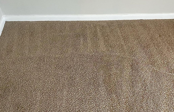 A close up of a brown carpet in a room.