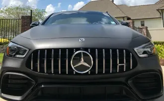 A mercedes benz amg gt63 s is parked in front of a house.