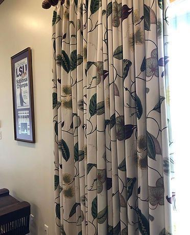 A pair of curtains with leaves on them are hanging on a window.