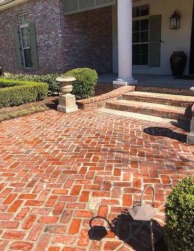 There is a brick walkway in front of a house.