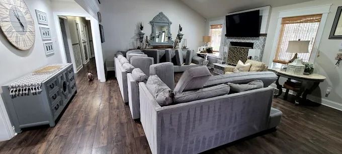 A living room with a large gray sectional sofa, fireplace, and ornate furniture.