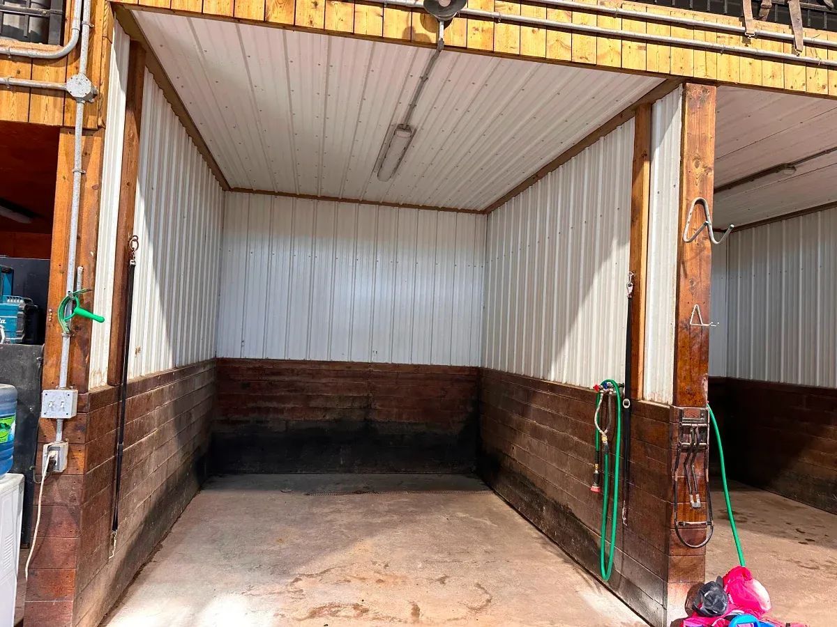 Empty horse stall with brown wooden framing