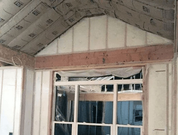 A house is being built with a vaulted ceiling and a window.