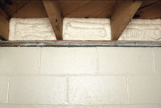 A white brick wall with wooden beams underneath it.