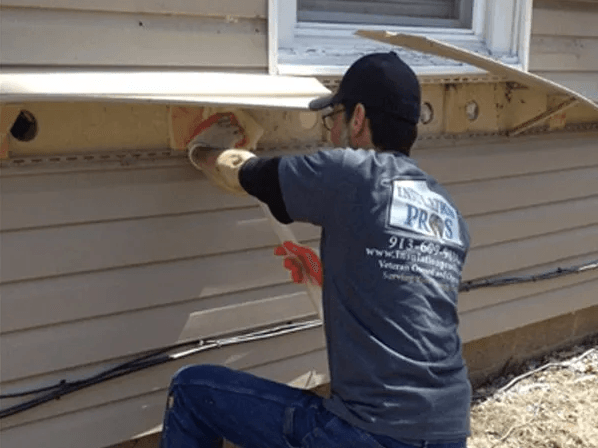 A man is working on the side of a house.