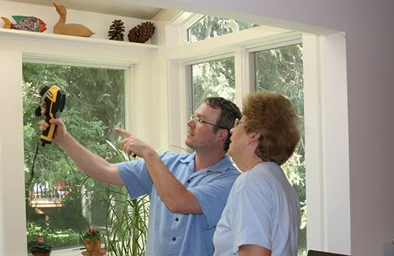 A man and a woman are looking at a window.
