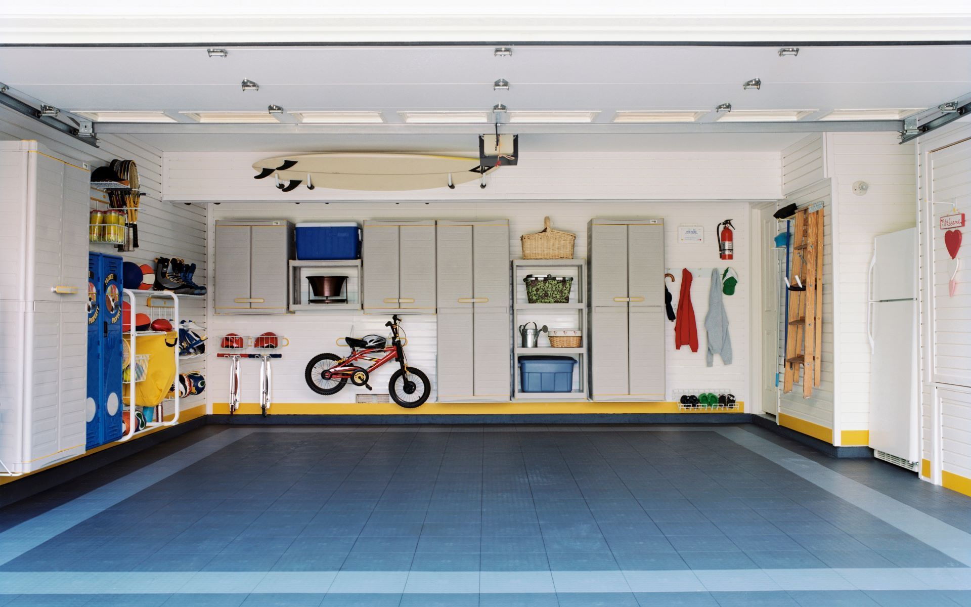 A garage with a bicycle and a surfboard on the wall