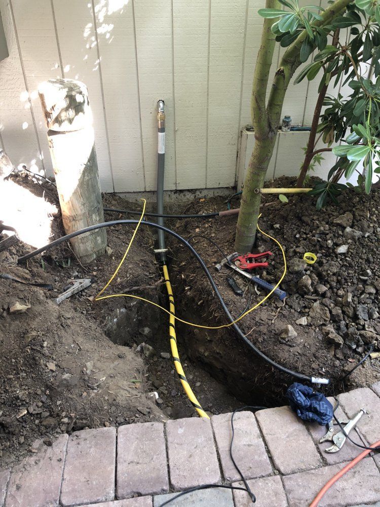 A Hose Is Being Installed in A Hole in The Ground – Hayward, Ca – Plumbing 1 Builders Inc.