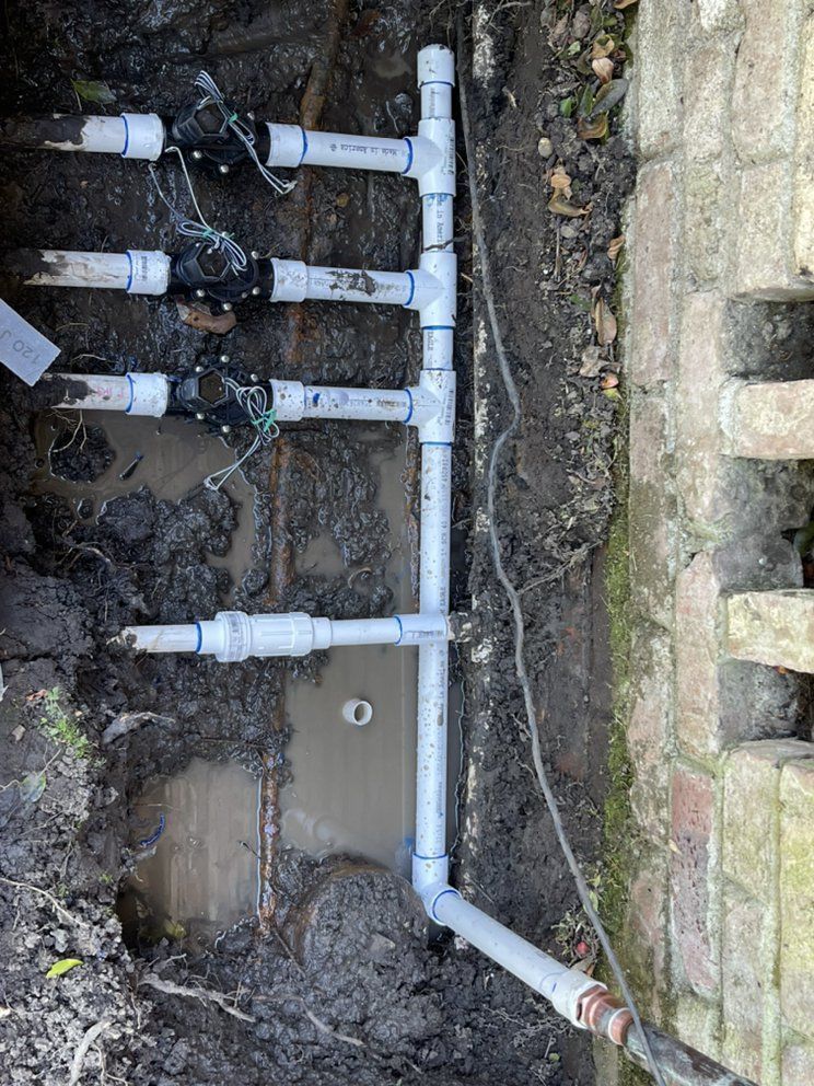 A Bunch of Pipes Are Laying in The Dirt Next to A Brick Wall – Hayward, Ca – Plumbing 1 Builders Inc.